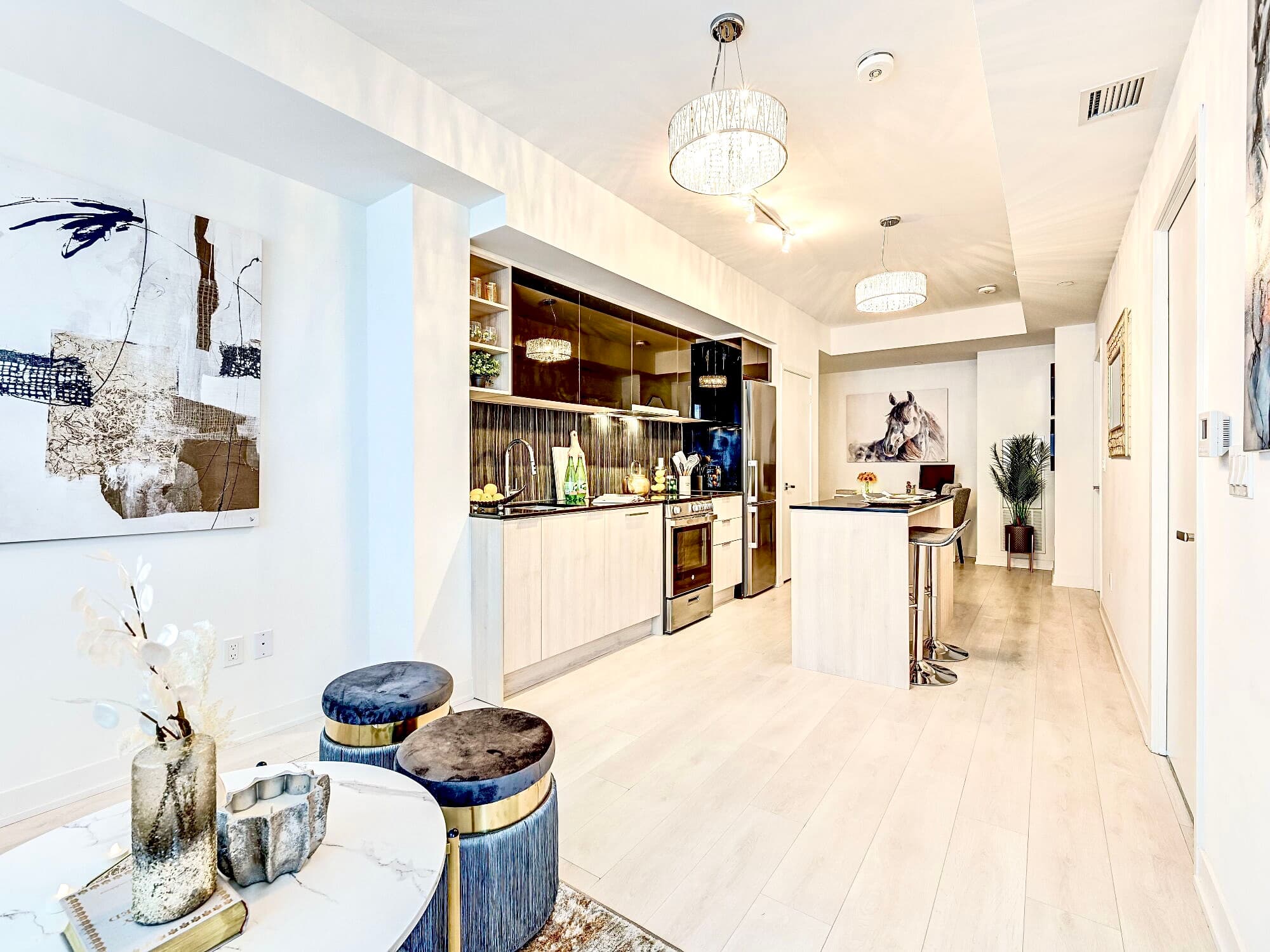 Bright, modern open-concept kitchen and living space featuring light wood cabinets and contemporary decor.